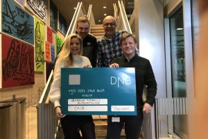 Sponsorssjef i DNB Tina Wesselsen overrekker sjekken til daglig leder Morten Grødahl, med Jens A. Dalsegg og Ole Ørbech smilende bak. Foto: DNB